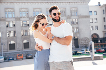 Smiling beautiful woman and her handsome boyfriend. Woman in casual summer clothes. Happy cheerful family. Female having fun. Couple posing in street at sunny day. Having tender moments. In sunglasses