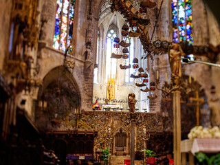 A vibrant church in Palma de Mallorca, Spain, adorned with numerous stained glass windows, captured with a tilt-shift lens.