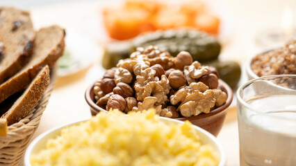 Walnuts, hazelnuts and almonds, millet porridge and a glass of clean water on the table during the...