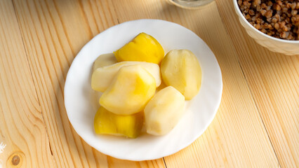 Lenten food during the Great Orthodox Lent, Boiled potatoes on a white plate on a wooden background