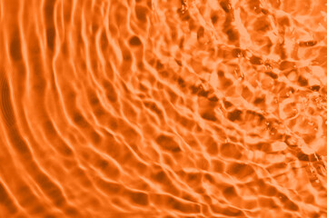 Rippled surface of clear water on orange background