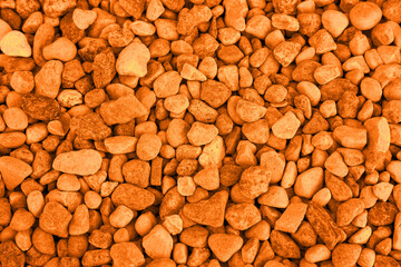 Pile of stones as background, top view. Toned in orange