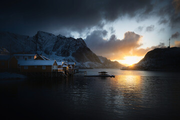Night winter photography of the fishing village Reine with snowy mountains in the background in the Lofoten Islands, Norway.