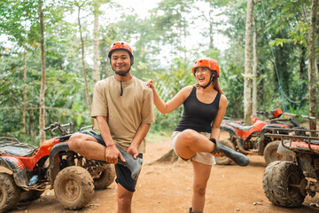 young asian couple joking while warming up before starts the atv tour © Odua Images