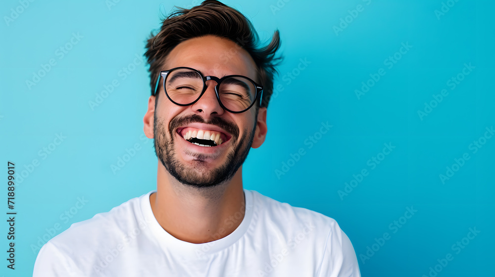 Wall mural very happy laughing man with glasses in front of blue background with copy space