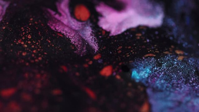 Sparkling paint flow. Glitter drops. Molten lava. Defocused blue red pink black color shimmering texture ink fluid wave motion abstract art background.