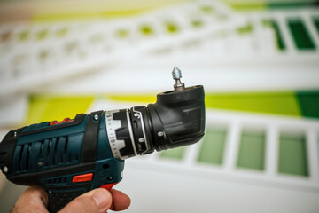 Assembling furniture using a drill with a metallic screw on the top of the flexi drill head for efficient and precise construction