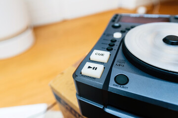 This image captures a close-up view of professional DJ equipment, focusing on the cue button and jog wheel, highlighting the intricacies of a DJs tools.