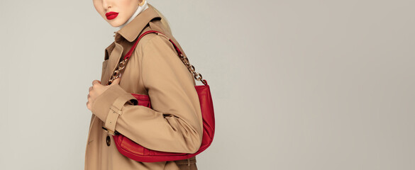 Clothing shopping. Autumn fashion concept. Fashionable young model with red lips make up posing...