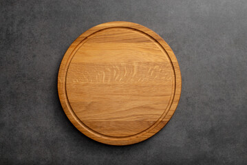 Empty wood round cutting board on black background