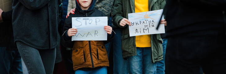 Two children holding stop war signs during a protest against the Russian invasion in Ukraine, showcasing youthful activism and hope.