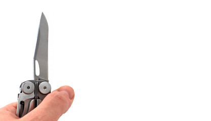 On a white background, a man's hand holds a steel multi-tool with an open knife blade. Pocket open folding knife. Portable multitasking multitool with many tools. EDC concept. 