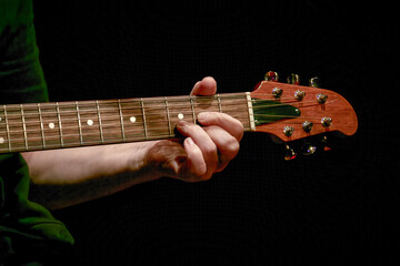  musician's fingers playing a chord on a guitar neck