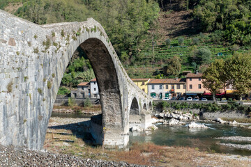 Fototapeta na wymiar Ancient stone bridge, the medieval Ponte Maddalena, or Devils Bridge, in Tuscany