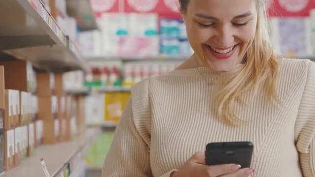 Woman using a smartphone at the grocery store