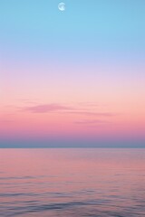 Naklejka na ściany i meble the moon hovering over the ocean at sunset on the beach