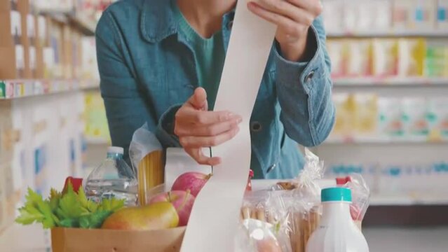 Desperate customer holding a long grocery receipt
