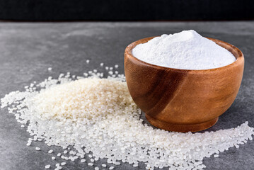 Rice flour in wooden bowl on gray background.