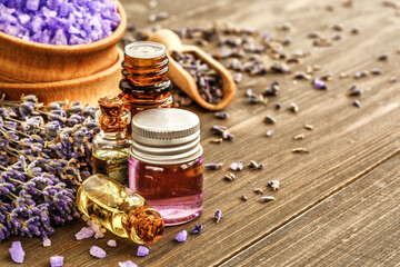 lavender's spa products with dried lavender flowers on a wooden table. Flat lay bath salt and massage oil on wooden background. Skin care, beauty treatment concept. Lavendula oleum