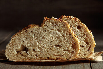 Bread, traditional sourdough bread cut into slices on a rustic wooden background. Concept of traditional leavened bread baking methods. Healthy food.