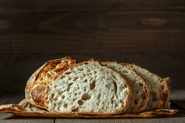Bread, traditional sourdough bread cut into slices on a rustic wooden background. Concept of...