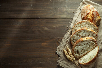 Bread, traditional sourdough bread cut into slices on a rustic wooden background. Concept of...