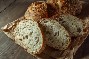 Bread, traditional sourdough bread cut into slices on a rustic wooden background. Concept of...