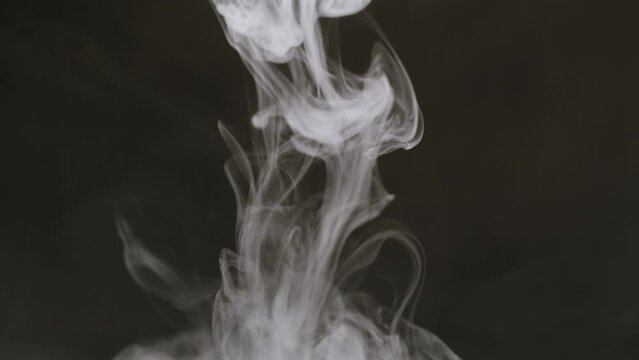Glass cone on black background in smoke. Chemical experiment close-up. Fog, smoking, vapour texture. 