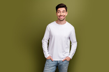 Portrait of positive nice man put arms pockets beaming smile look empty space isolated on khaki...