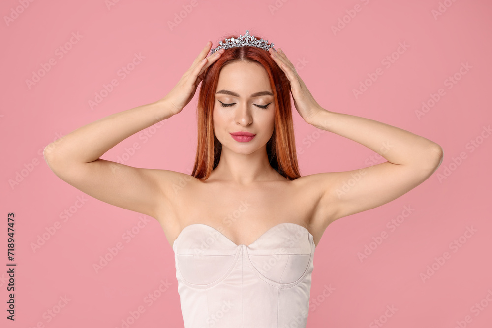 Poster Beautiful young woman with tiara on pink background