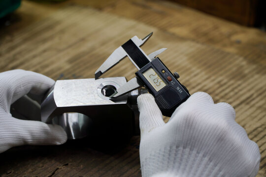 Technicians measure the diameter of the workpiece in the factory acceptance testing process with a digital Vernier caliper before delivery.