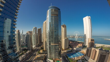 Panoramic view of the Dubai Marina and JBR area and the famous Ferris Wheel aerial night to day...