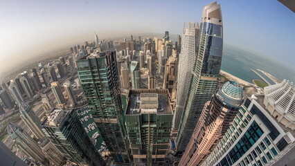 Skyline panorama of Dubai Marina showing canal surrounded by skyscrapers along shoreline night to...