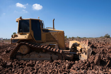 Dozer is pushing dirt. Bulldozer is working  gravel surface for new road.