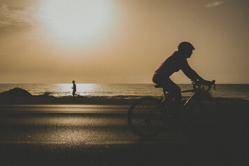 Obraz na płótnie Canvas Personas haciendo deporte running y bicicleta al amanecer y puts de sol , People doing sports running bike at dawn sunset