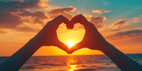 A close-up of hands forming a heart shape with a beautiful sunset in the background - love and togetherness concept Ideal for romantic themes and greeting cards