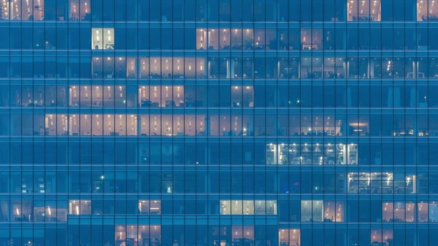 Day to night transition blinking office window lights time-lapse, windows grid, high-rise skyscraper business buildings in downtown, glass surface, turn on and off lights, people working in evening