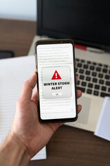 Winter storm alert notification appearing on the phone while in use. Vertical shot.
