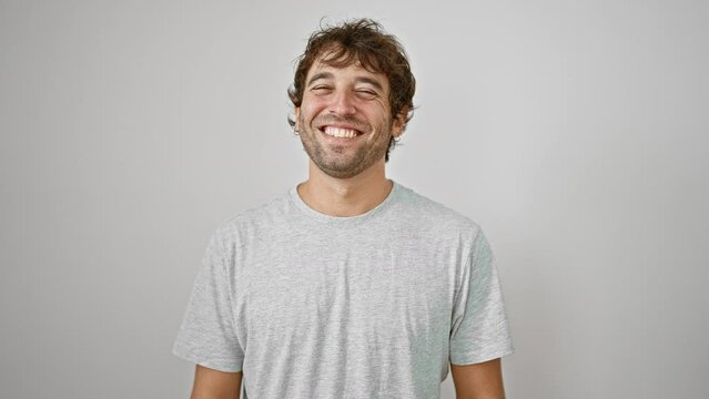 Handsome young man in casual t-shirt sticks his tongue out for a fun, positive expression of joy and happiness, isolated on white background.
