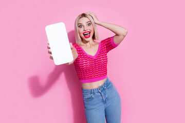 Photo of ecstatic woman with bob hair dressed knit top demonstrate crazy discount on smartphone display to you isolated on pink background