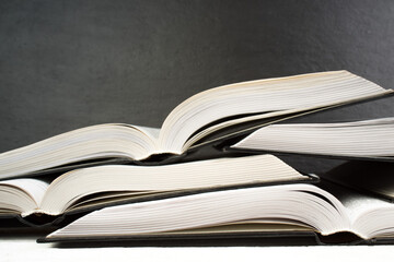 Open book on wooden deck table and black board background. Back to School. Education concept with copy space for your ad text.