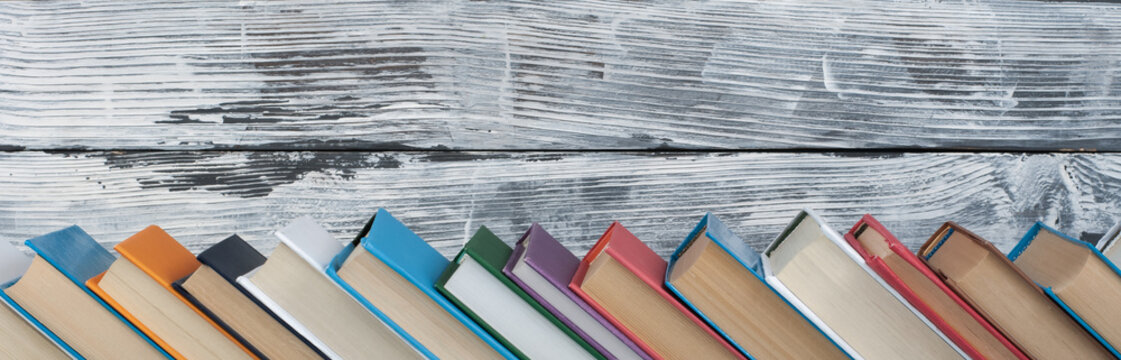 Stack of colorful books. Education background. Back to school. Book, hardback colorful books on wooden table. Education business concept. Copy space for text. panorama, banner.