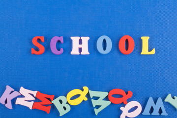 SCHOOL word on blue background composed from colorful abc alphabet block wooden letters, copy space...