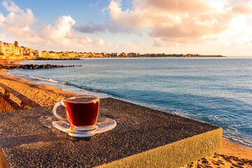 concept of street outdoor breakfast with a cup of tea or coffee on a morning coast during sunrise....