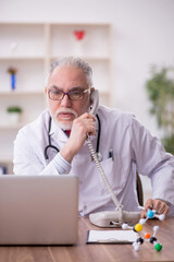 Old male doctor in telemedicine concept