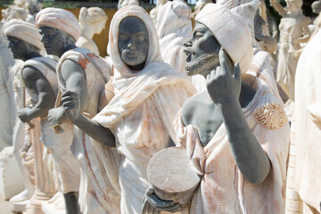 Marble sculptures of men of black marble in draped garments of light marble are put on sale outside...