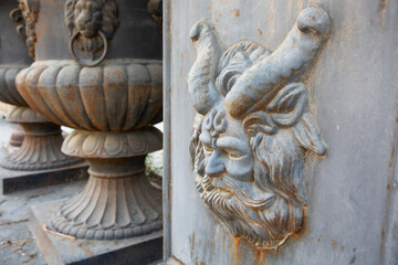 Metal vases with bas-relief in the form of a fauna face with horns are for sale. Aged, rusted metal vases.