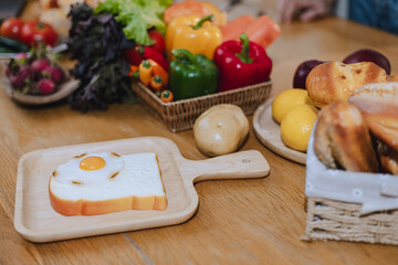 Bread and fried eggs are placed on the kitchen table, Egg on toast that has been placed on top of wood table.