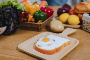 Bread and fried eggs are placed on the kitchen table, Egg on toast that has been placed on top of wood table.
