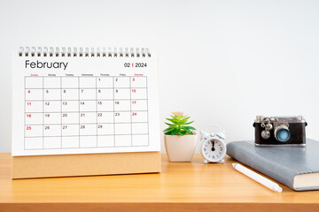 Desktop Calendar for February 2024 year and vintage camera with diary for Planner to plan timetable.